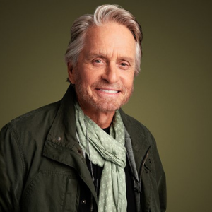 Michael Douglas smiling wearing muffler and a green jacket